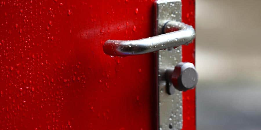 a red door with steel lock and handle